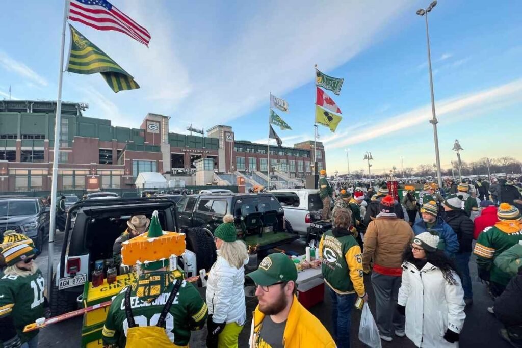 Tailgating at Lambeau Field: The Ultimate 2025 Green Bay Stadium Pre-Game Experience Guide 6 Fans tailgating with grills and tents in the parking lot near Lambeau Field stadium on a clear day.